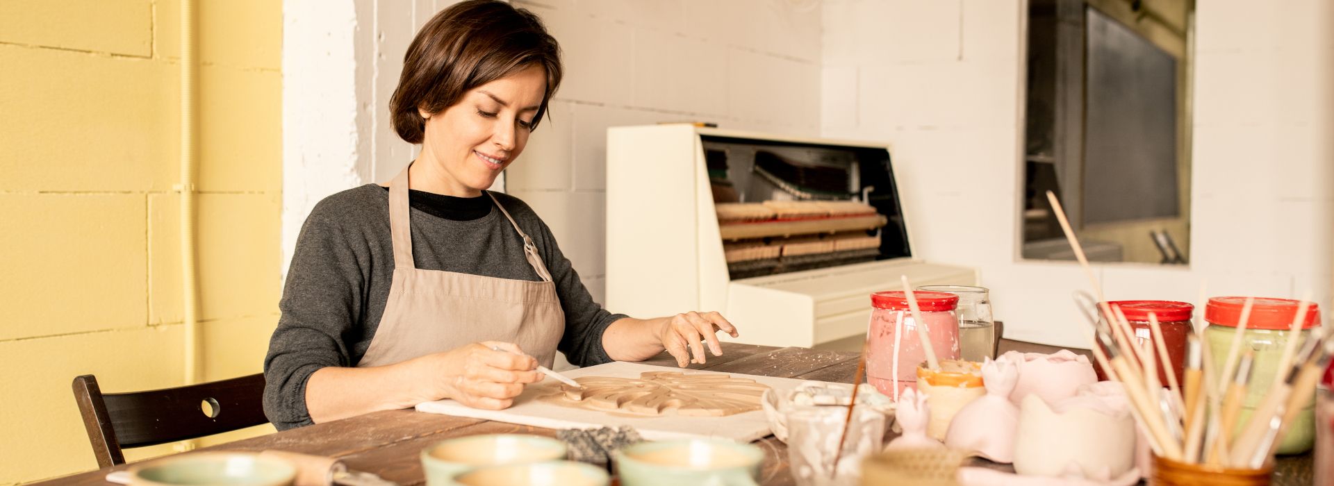 pittrice mentre sta lavorando la maiolica di Castelli in laboratorio