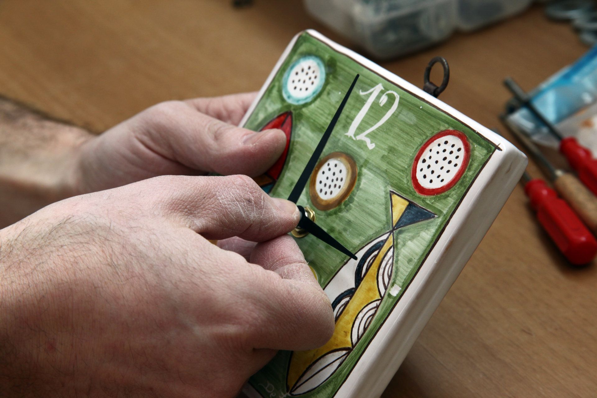 artigiano che assembla orologio dipinto a mano di argilla a Castelli in Abruzzo De Fabritiis